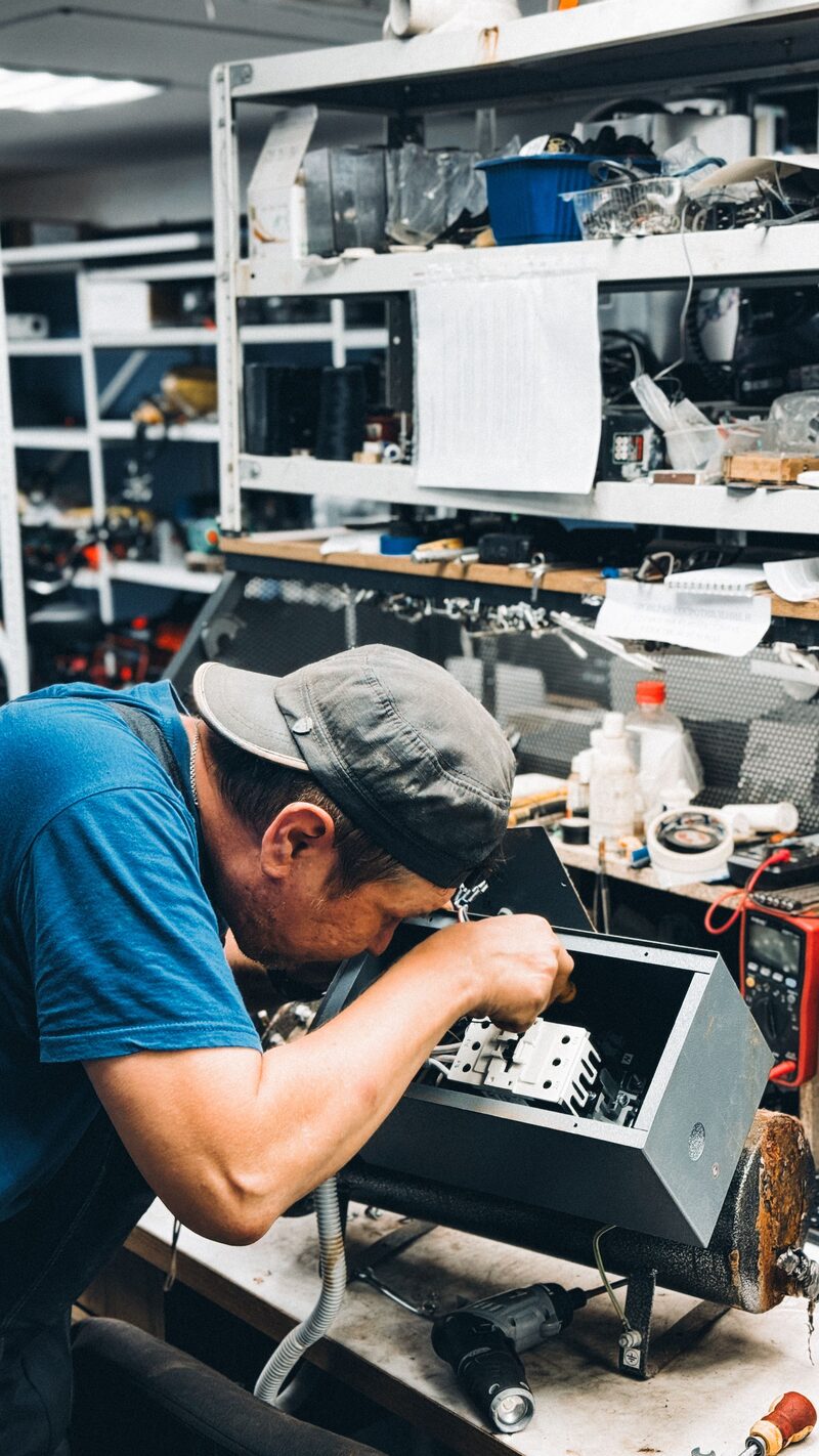 Elektroinstallation an einer Rohbauwand, Arbeiter auf einer Leiter